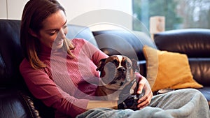 Woman With Prosthetic Arm And Hand At Home With Pet Dog 