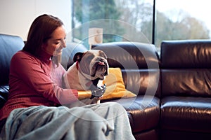 Woman With Prosthetic Arm And Hand At Home With Pet Dog 