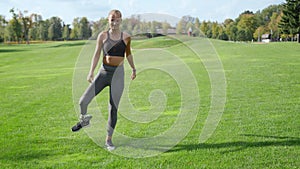 Woman with prosthetic leg warming in park. Girl exercising outdoors