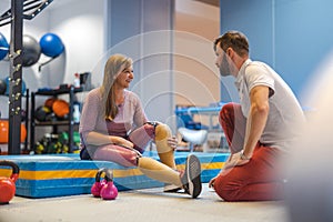 Woman with prosthetic legs talking to a physiotherapist