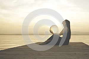 Woman protecting a magical sphere illuminated by the sun that releases energy and inner strength, abstract concept photo