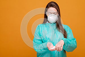 woman with protective equipment and pills in hand in medical mask on yellow background, coronavirus pandemic
