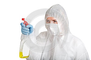 Woman in protective gloves and suit making cleaning and desinfection