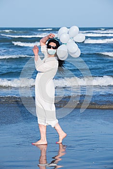 Woman with protective mask on the beach