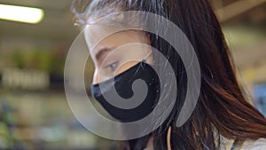 woman in protective mask, choosing products in supermarket. Face close up