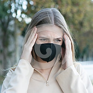 Woman with a protective mask having headache