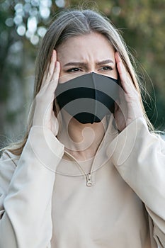 Woman with a protective mask having headache