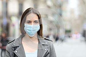 Woman with protective mask looking at camera on street