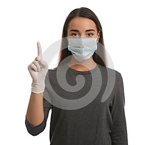 Woman in protective mask and medical gloves with raised index finger on white background