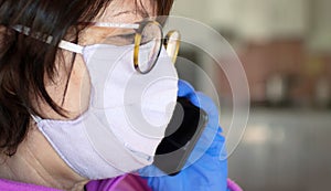 Woman in protective mask and protective gloves talking on phone while coronavirus and pandemic. Business and work online while
