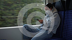 Woman in protective mask rides public transport. Young female traveling by train