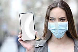 Woman with protective mask showing phone screen