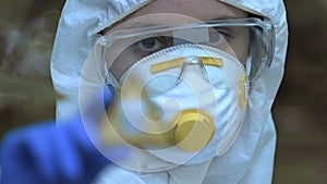 Woman in protective mask showing poison sign, toxic waste disposal, pesticides