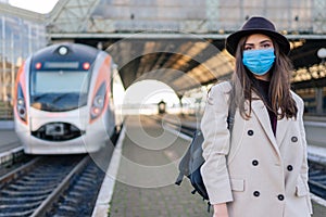 Woman in protective medical mask at the railway station. Tourism during the epidemic concept.