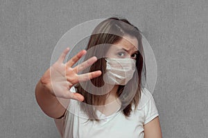 Woman in protective medical mask and showing gesture Stop virus