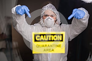 Woman in protective suit and in protective medical mask showing sign. Epidemiologist show stop palm. Stop coronavirus or