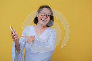 Woman proudly showing her cellular phone in her hand with a big smile photo