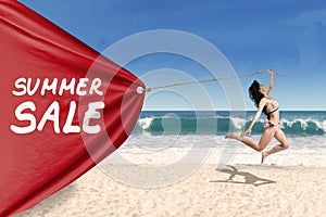 Woman pulling a banner of summer sale