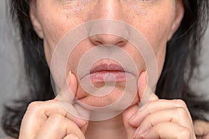 Woman pulling down the sides of her mouth