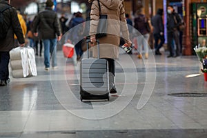 Woman pulling her trolley in a train station