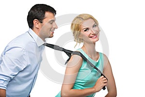 Woman pulling man for his tie