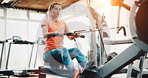 Woman pulling on row machine in fitness