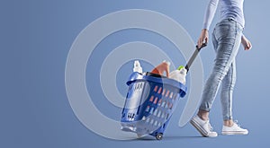 Woman pulling a shopping basket full of cleaning products