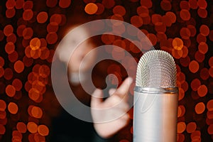 Woman pulls hand to microphone for sing at concert.