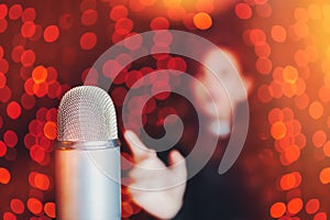 Woman pulls hand to microphone for sing at concert.