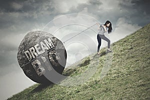 Woman pulls stone with Dream Big text