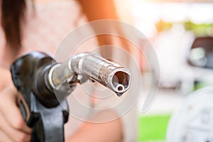 Woman pumping gasoline fuel in car at gas station. photo