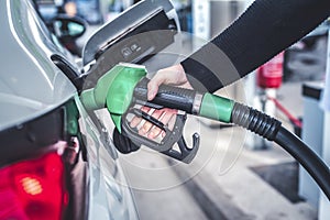 Woman pumping gasoline fuel in car at gas station. photo