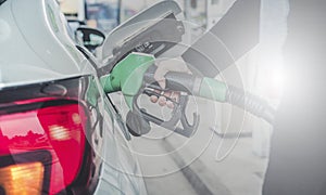 Woman pumping gasoline fuel in car at gas station. photo