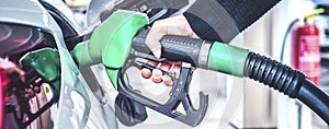 Woman pumping gasoline fuel in car at gas station. photo