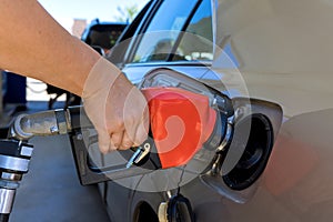 Woman pumping gasoline fuel in car at gas station