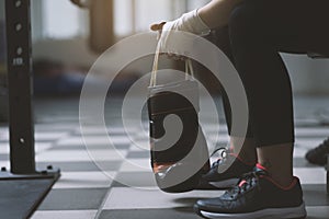 Woman with punching gloves resting on a bench