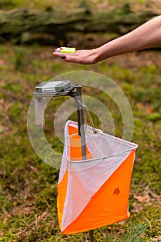 A woman punching at the orienteering control point