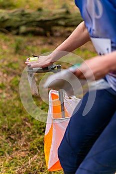 A woman punching at the orienteering control point