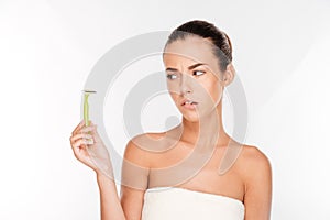 Woman with pure skin holding razor blade preparing to shave photo