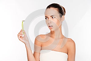 Woman with pure skin holding razor blade preparing to shave