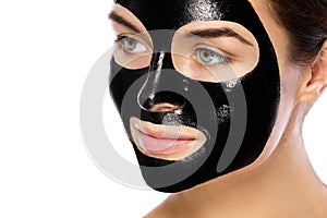 Woman with purifying black mask on her face