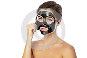 Woman with purifying black mask on her face