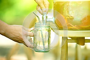 Woman puring lemonade in her masson jar
