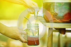 Woman puring lemonade in her masson jar