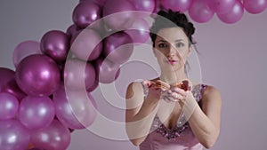 Woman in purple dress with sequins stretches his arms forward