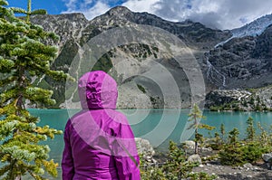 Woman in Purple Rain Jacket at Mountain Lake