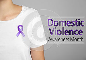 Woman with purple ribbon on grey background. Symbol of Domestic Violence Awareness