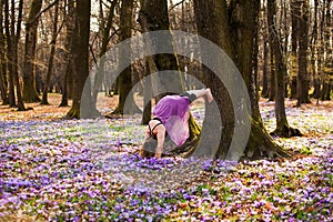 Woman in purple skirt standing upside down outdoors