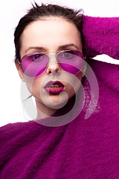 woman in purple sweater, purple glasses with purple lipstick on her lips