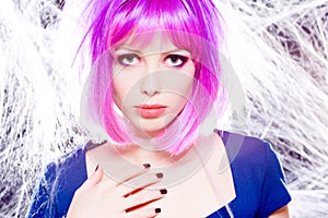 Woman with purple wig and intense make-up trapped in a spider web